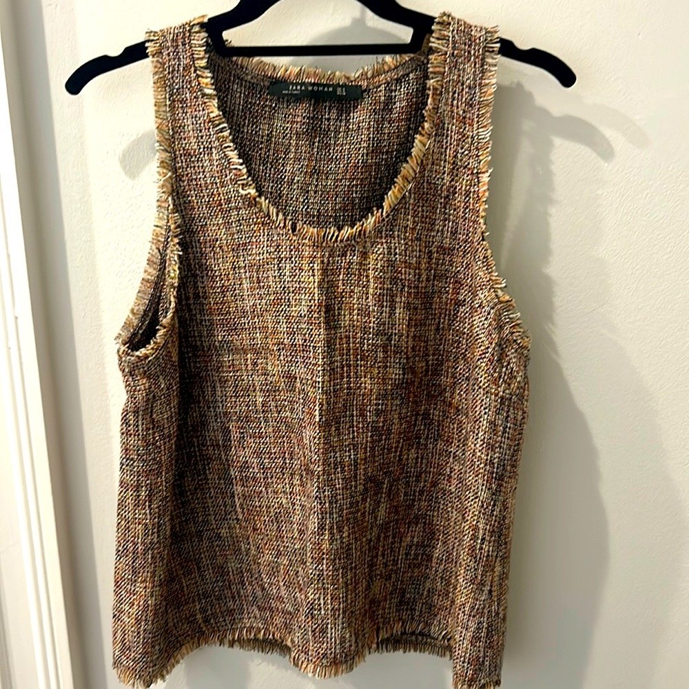 Pullover,slight racerback, sleeveless, fringe around sleeves,neck and bottom